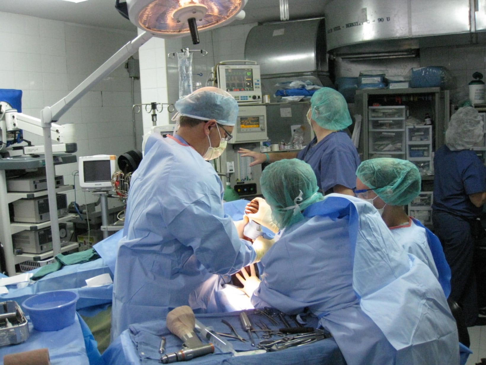 A group of people in a surgical room posing for photos.