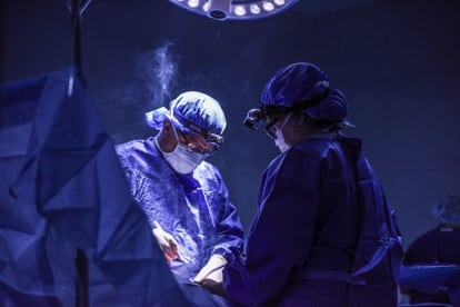 Two surgeons performing surgery in an operating room on Day #4.