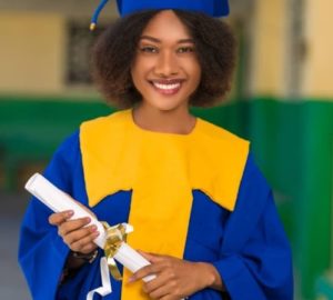A young woman in a blue graduation gown holding a diploma is the representation of achievement and success.