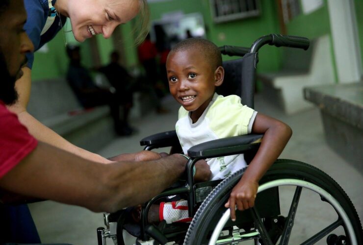 A young boy in a wheelchair receiving assistance from a compassionate nurse.